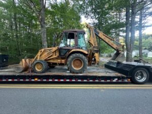 Transporting a 1990 Case 580K Backhoe Loader on a RGN trailer.