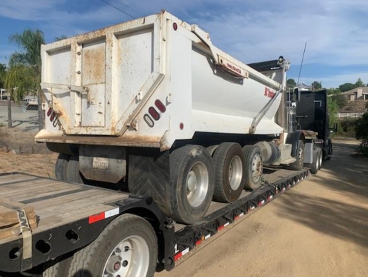 Transporting a 2013 Peterbilt 312 dump truck on a lowboy trailer.
