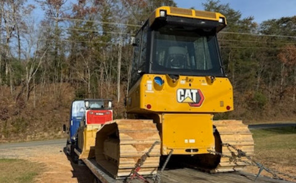 Hauling a 2025 Caterpillar D1 dozer on a flatbed trailer.