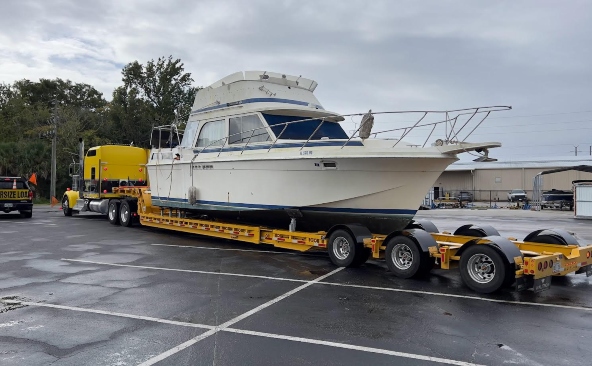 Transporting a 36-foot Uniflite double cabin on a multi-axle hydraulic lowboy boat transport trailer.