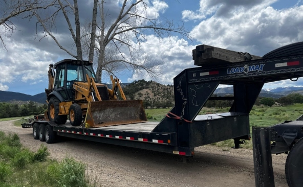 Backhoe loader transportation on a gooseneck hotshot trailer.