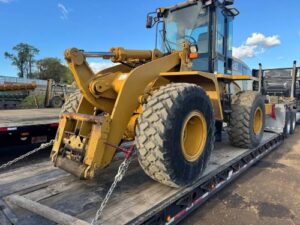 Transporting a Caterpillar 938G wheel loader on a lowboy trailer.