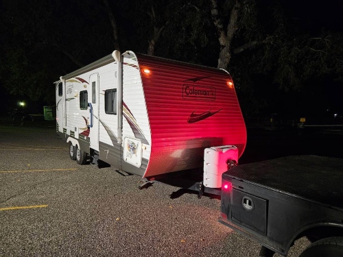 Bumper-pull tow setup with a ball and hitch connection to haul a Coleman travel trailer.