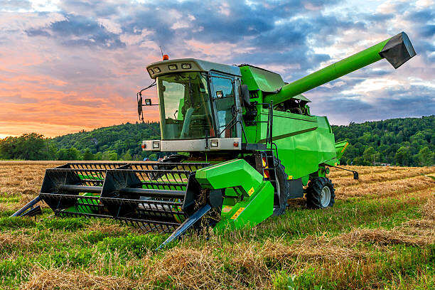 Big green combine harvester in sunset light Heavy Equipment Transport from Missouri to Florida