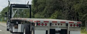 Flatbed trailer transporting machinery and attachments