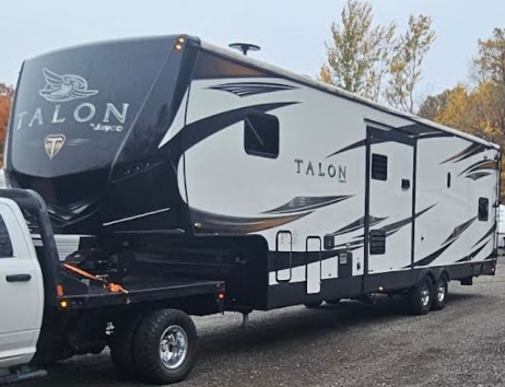 RAM 3500 pickup truck pulling a 2019 Jayco Talon 413T for a transport service.