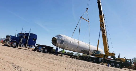 Mobile hydraulic crane loading a Airliner fuselage on a extendable RGN lowboy trailer.