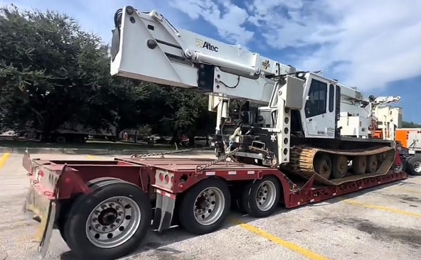 Hauling a Altec DC-DM47 Digger Derrick on a double-drop lowboy trailer.