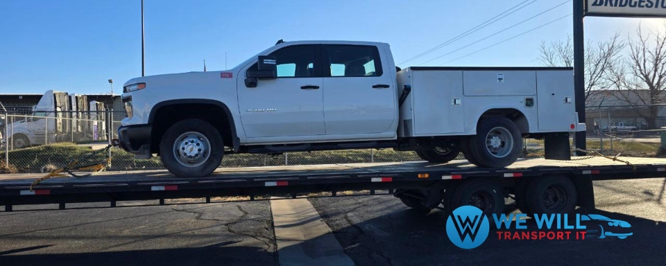 Moving a a Chevrolet Silverado 3500HD work truck on a gooseneck flatbed trailer.