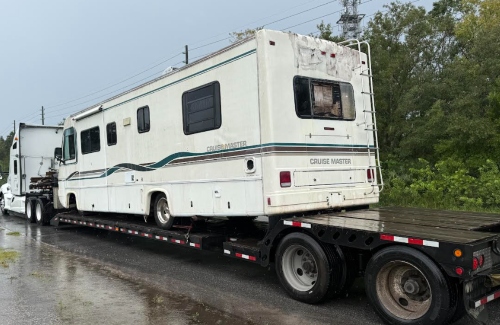 Hauling a Georgie Boy Cruise Master on a lowboy trailer.