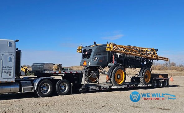 Hauling a Hagie STS Series Self-Propelled Crop Sprayer on a RGN trailer.