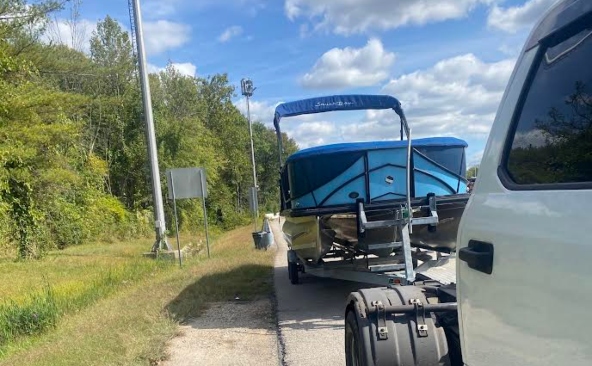 Hook and pull transport of a Pontoon boat on a trailer.