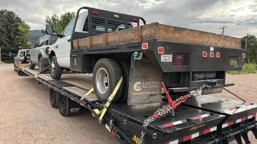 Hauling a Ram 3500 flatbed truck and a Ford Bronco Sport SUV on a gooseneck flatbed trailer.