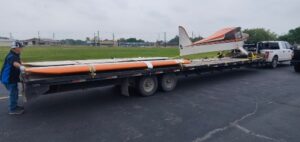 Hauling a small single-engine airplane Hauling a small single-engine airplane on a gooseneck flatbed trailer.
