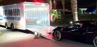 How Much Does It Cost To Ship A Car To Another State? Huge enclosed car transport trailer and a Ferrari car ready to be on the trailer