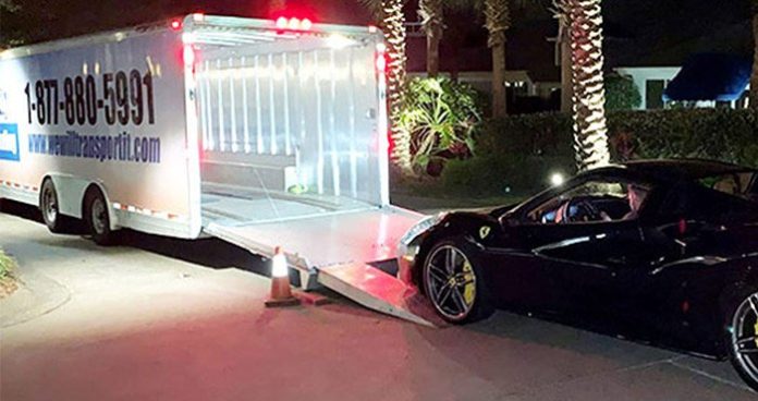Huge enclosed car transport trailer and a Ferrari car ready to be on the trailer