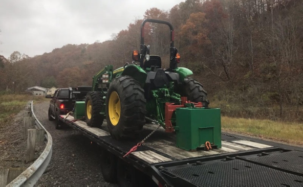 John Deere 5045e tractor with ballister bucket hauled on a hot shot trailer.