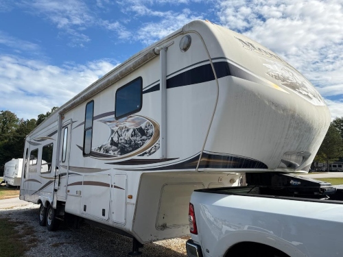 Montana fifth wheel being pulled by a truck for transport.