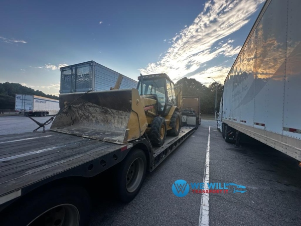 Caterpillar 430D Backhoe on a lowboy trailer for transport from Tupelo, Mississippi to Little Rock, Arkansas.