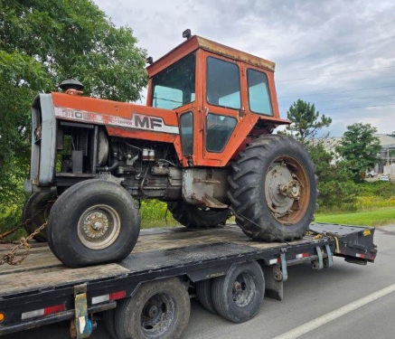 Massey Ferguson farm tractor secured on a flatbed for transport.