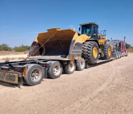 Caterpillar wheel loader on an RGN lowboy trailer.