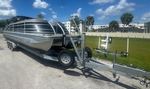 Shipping a Luxury Pontoon Boat on a triple-axle bunk-style trailer.