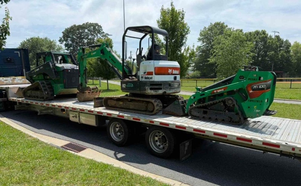 Shipping three Bobcats on a step deck trailer.