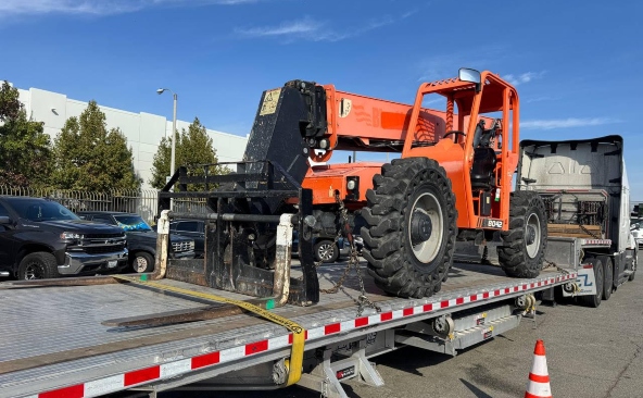 Hauling a SkyTrak 10054 telehandler on a step deck trailer.