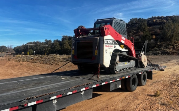 Transporting a Takeuchi TL12V2 compact track loader on a hotshot trailer.