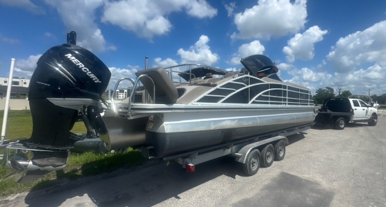 Transporting a Luxury Pontoon Boat on a triple-axle bunk-style trailer.