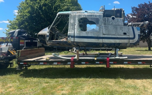 Transporting a fuselage section of helicopter on a flatbed trailer.