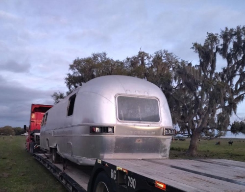 Hauling a Vintage Airstream travel trailer on a lowboy trailer.
