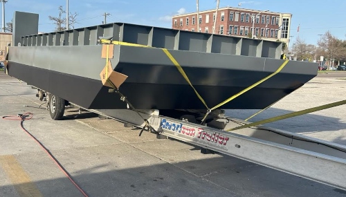 Work utility barge strapped down on a boat trailer for transport.