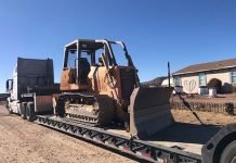 The Complete Guide to Equipment Hauling Services Heavy machinery on a flatbed trailer - equipment hauling