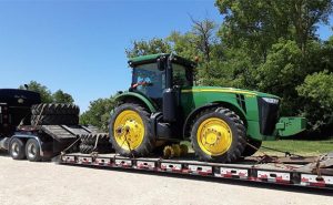 Shipping a John Deere farm tractor on a lowboy trailer.